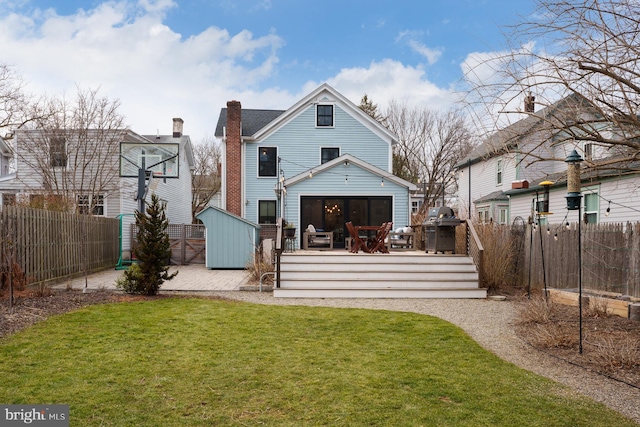 back of property featuring a lawn, a fenced backyard, and a wooden deck