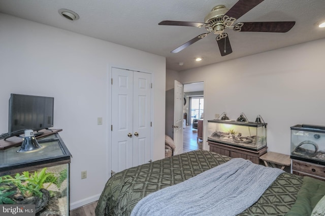 bedroom with hardwood / wood-style flooring, ceiling fan, and a closet