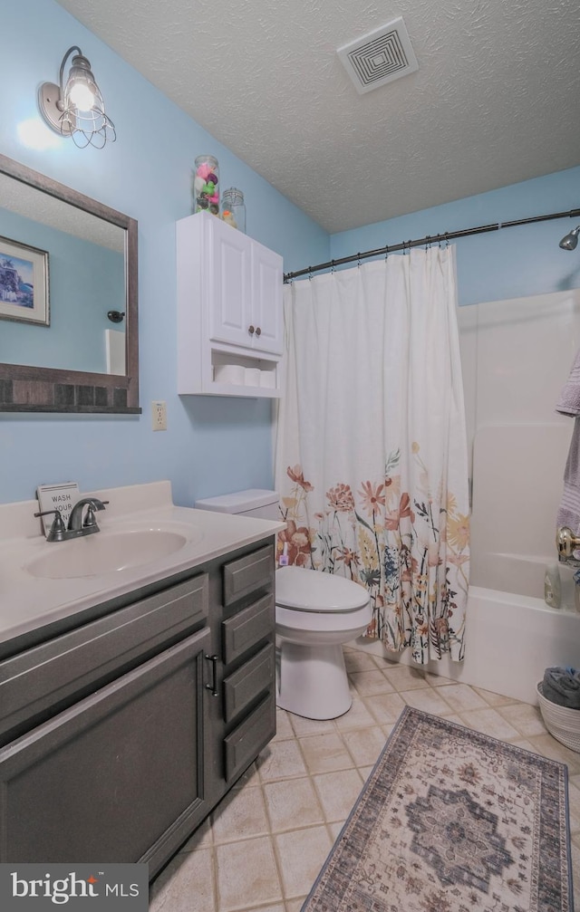 full bathroom with vanity, a textured ceiling, tile patterned floors, toilet, and shower / bath combo with shower curtain