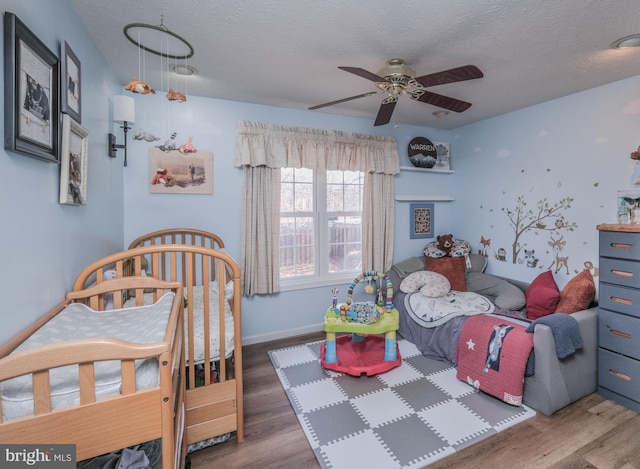 bedroom featuring ceiling fan, a textured ceiling, and dark hardwood / wood-style flooring