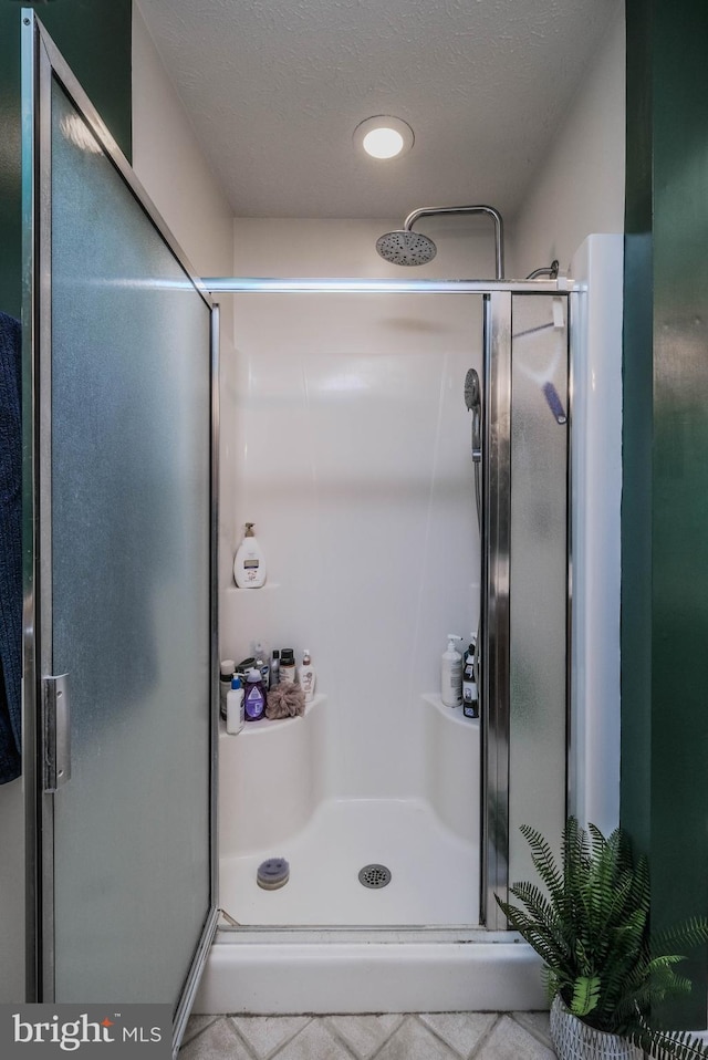 bathroom with a textured ceiling and walk in shower