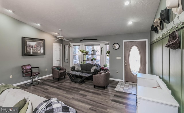 living room featuring vaulted ceiling, ceiling fan, a textured ceiling, and dark hardwood / wood-style flooring