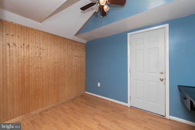 bonus room with ceiling fan, lofted ceiling, light hardwood / wood-style flooring, and wood walls