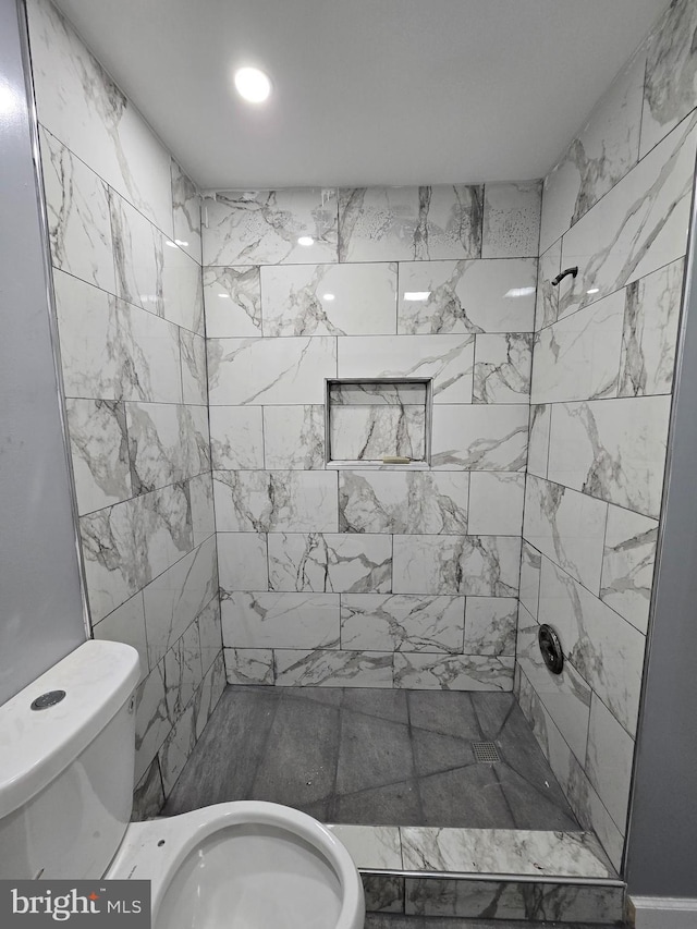 bathroom with tiled shower and toilet