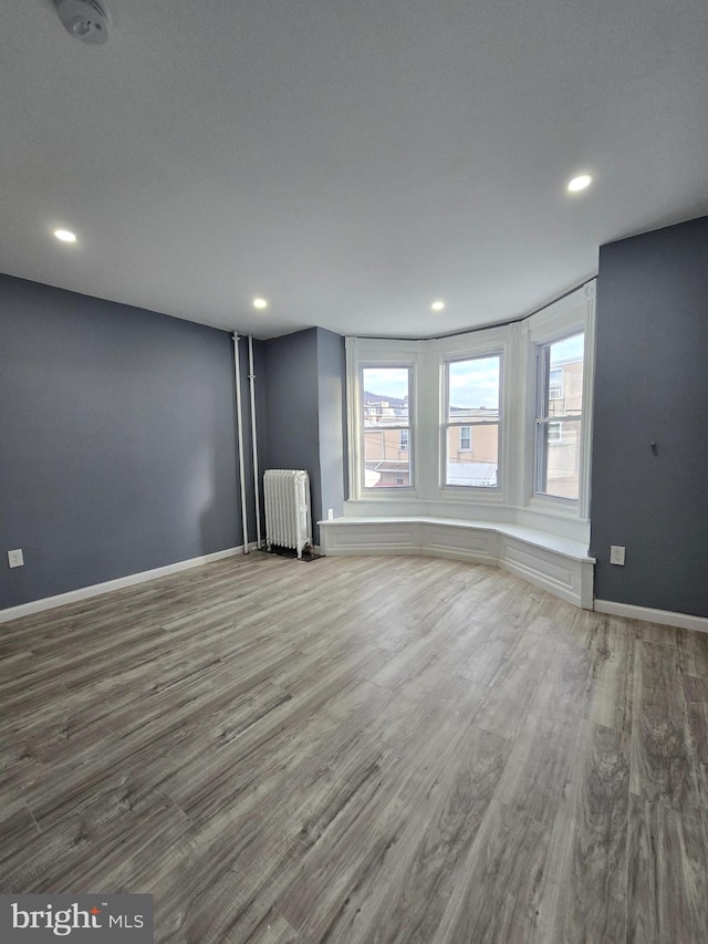 interior space with hardwood / wood-style flooring and radiator heating unit