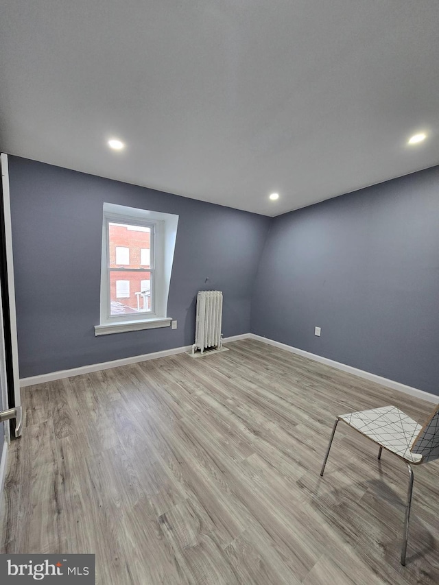 empty room with radiator and light hardwood / wood-style floors