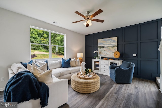 living room with dark wood-type flooring and ceiling fan