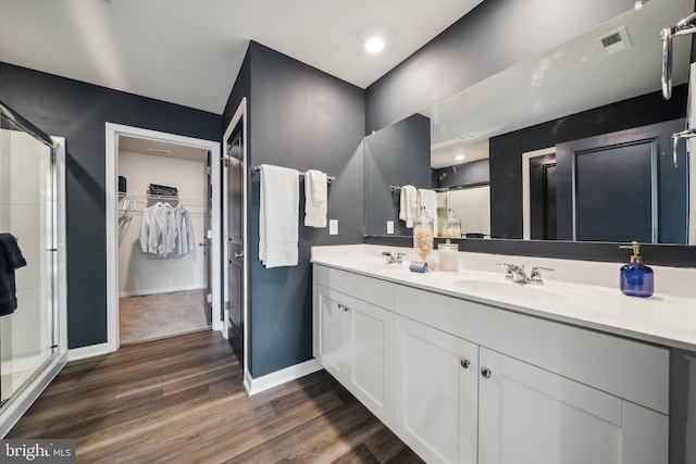 bathroom featuring wood-type flooring, an enclosed shower, and vanity