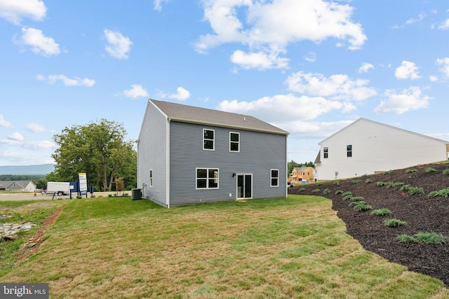 back of house with a yard and central AC