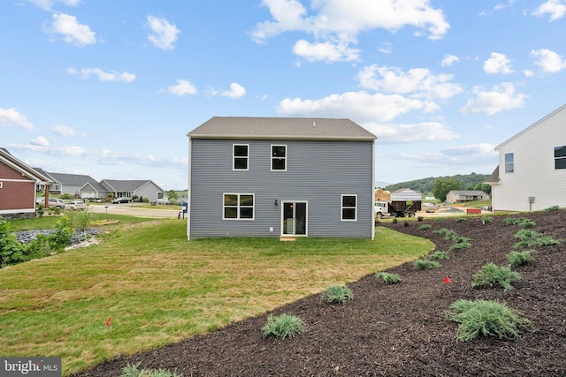 rear view of property featuring a yard