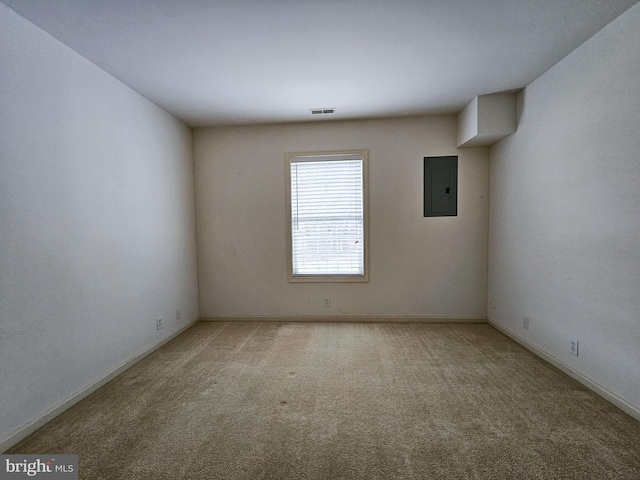 unfurnished room featuring light carpet and electric panel