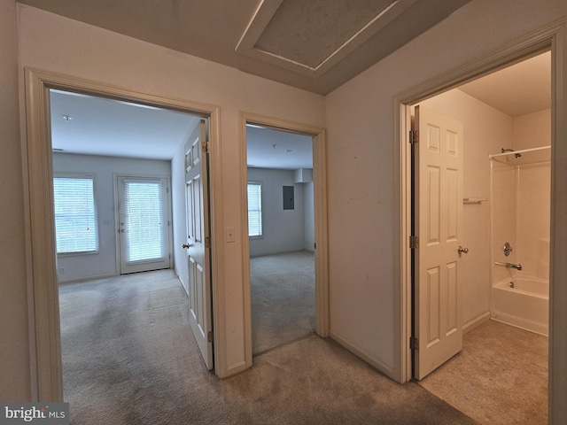 hallway with light carpet and electric panel