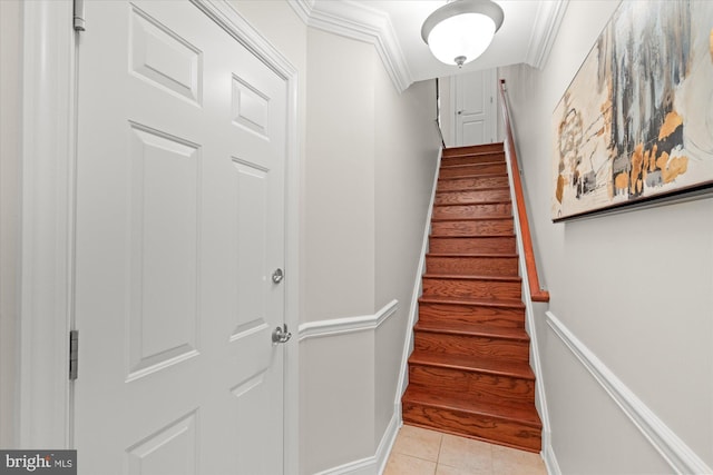 stairs featuring tile patterned floors and ornamental molding