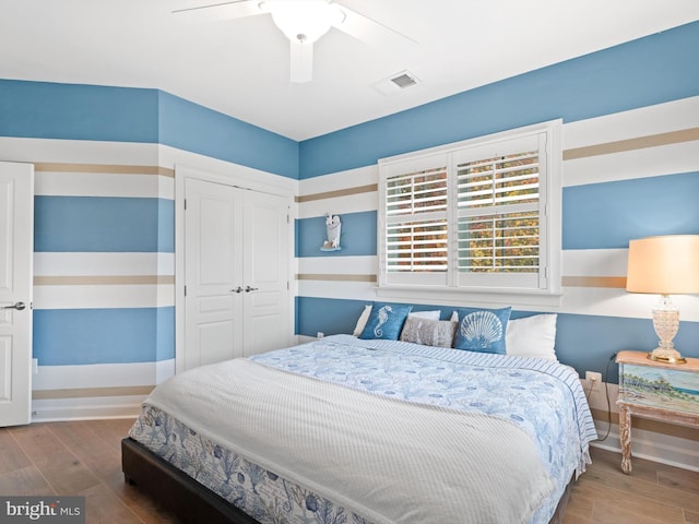 bedroom featuring hardwood / wood-style floors, a closet, and ceiling fan