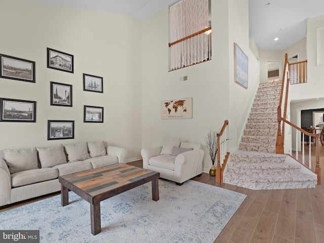 living room with hardwood / wood-style flooring and a high ceiling