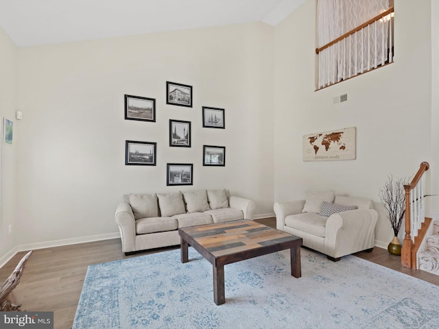 living room featuring wood-type flooring and high vaulted ceiling