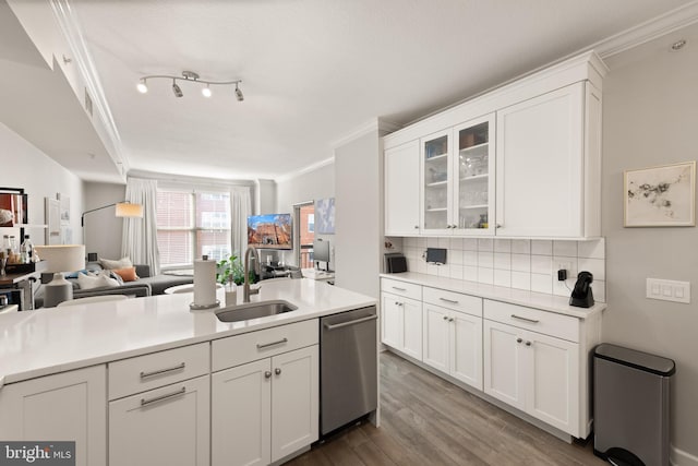 kitchen with dishwasher, sink, white cabinets, and decorative backsplash