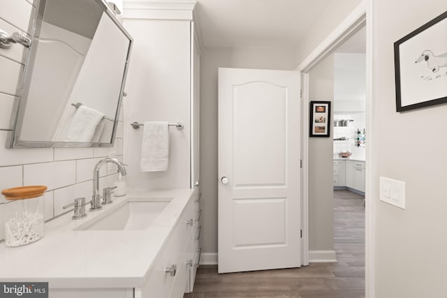 bathroom with tasteful backsplash, vanity, and wood-type flooring