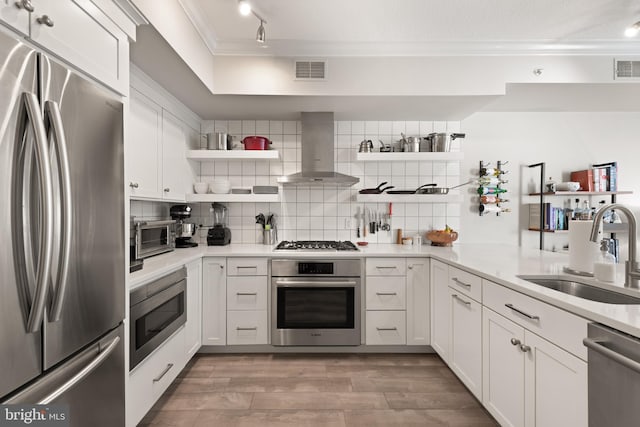 kitchen with stainless steel appliances, island exhaust hood, sink, and white cabinets