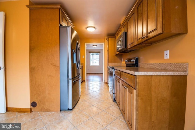 kitchen with appliances with stainless steel finishes and light tile patterned floors