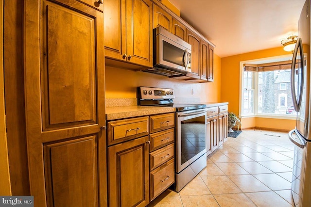 kitchen with light tile patterned floors and appliances with stainless steel finishes