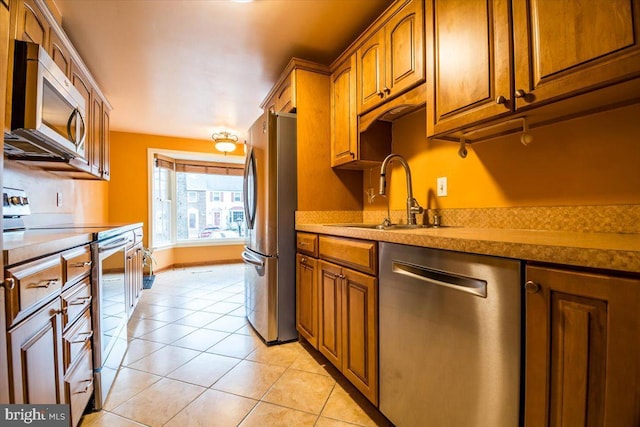 kitchen with sink, stainless steel appliances, and light tile patterned flooring