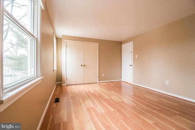 unfurnished bedroom featuring light hardwood / wood-style floors and a closet