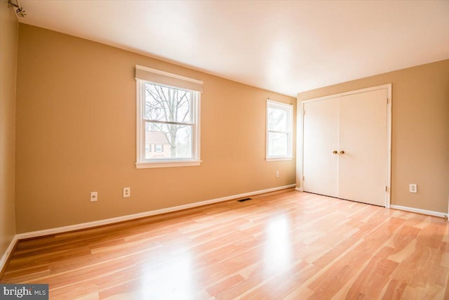 unfurnished bedroom featuring a closet and light wood-type flooring