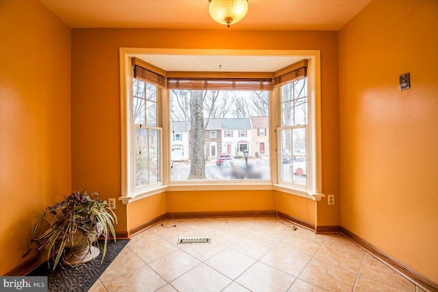 unfurnished dining area featuring a healthy amount of sunlight and tile patterned floors