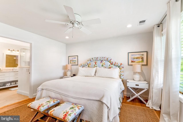 bedroom featuring ensuite bath, wood-type flooring, and ceiling fan