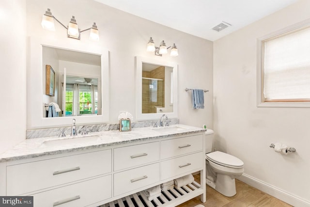 bathroom featuring vanity, an enclosed shower, toilet, and ceiling fan