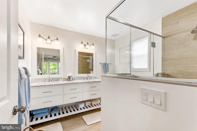 bathroom with vanity, hardwood / wood-style flooring, and a shower with door