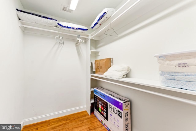 spacious closet featuring heating unit and light wood-type flooring