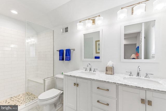 bathroom featuring tiled shower, vanity, and toilet