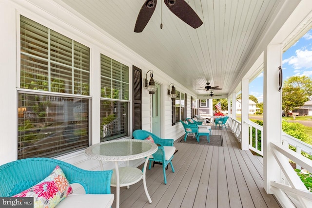 wooden terrace featuring covered porch and ceiling fan