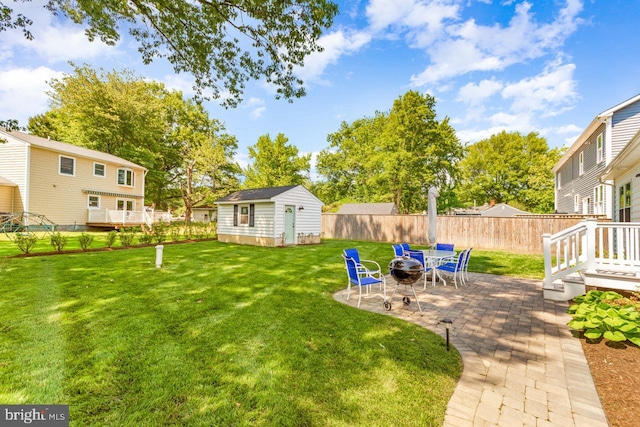 view of yard with a patio, a storage unit, and a fire pit