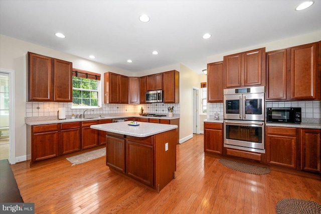 11050 Sanandrew Dr, New Market, MD 21774 - kitchen featuring stainless steel appliances, light countertops, a sink, backsplash, and light wood-style flooring