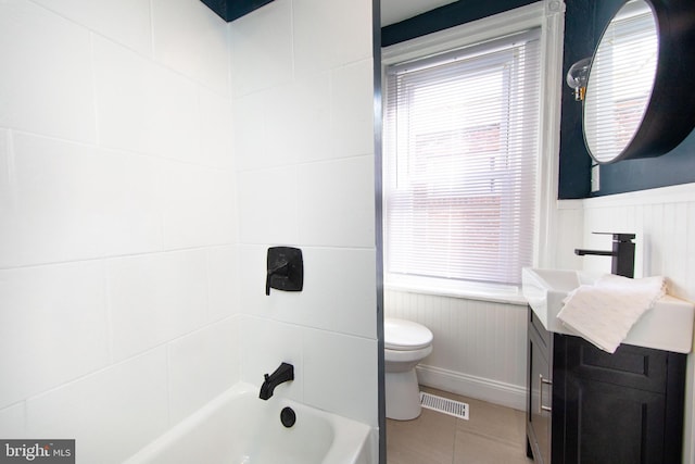 full bathroom featuring vanity, tiled shower / bath, and toilet