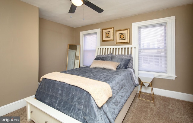 carpeted bedroom with ceiling fan and multiple windows