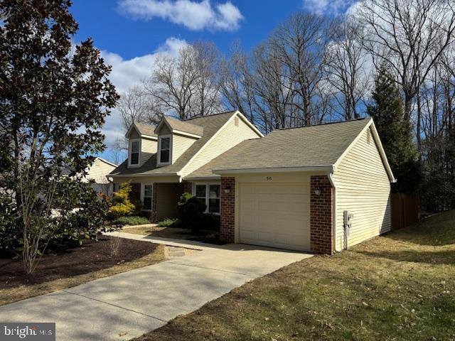 view of front of property with brick siding, driveway, a front lawn, and a garage