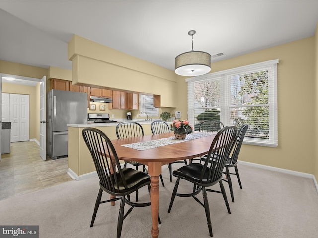 dining space with baseboards, light carpet, and visible vents