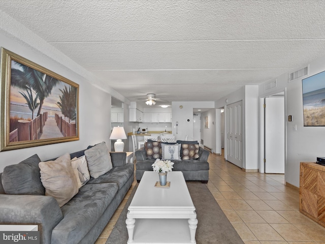 living room with a textured ceiling and light tile patterned floors