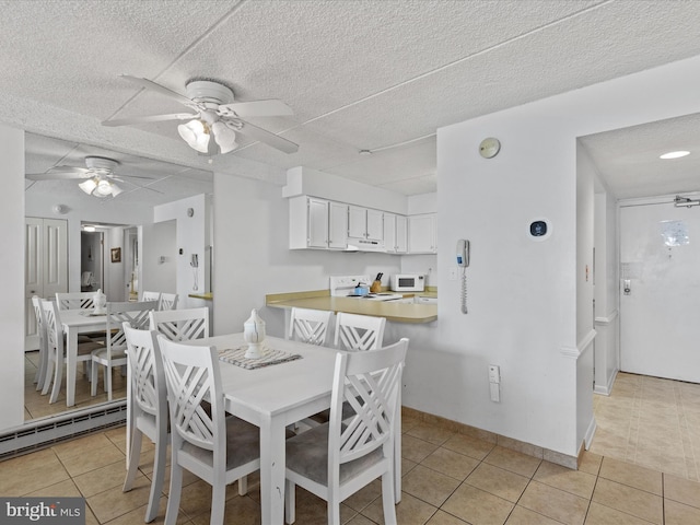 tiled dining room with ceiling fan, a baseboard radiator, and a textured ceiling