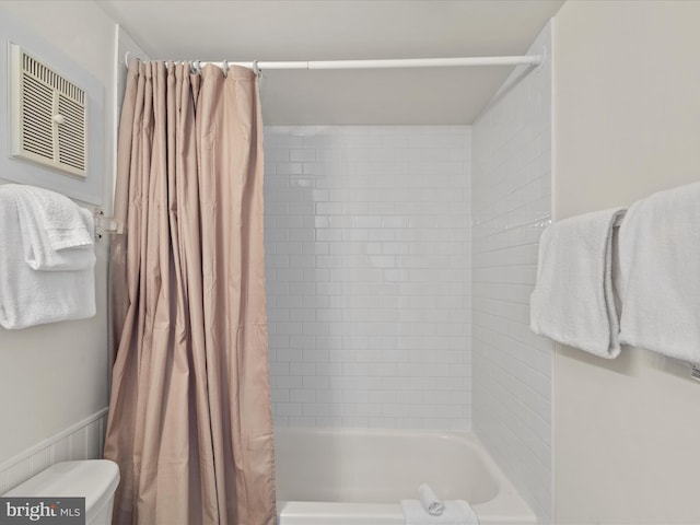 bathroom with toilet and shower / bath combo with shower curtain