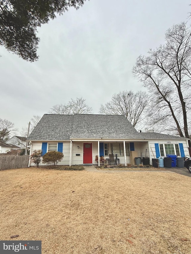 ranch-style house featuring covered porch and a front lawn