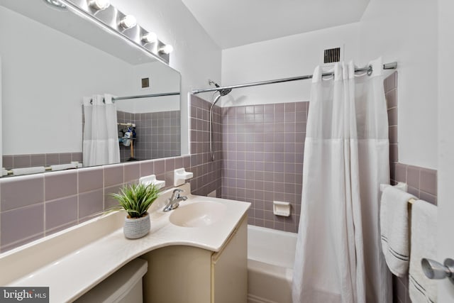 bathroom with tasteful backsplash, vanity, and shower / bath combo with shower curtain