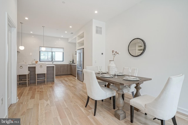 dining space featuring sink and light hardwood / wood-style floors