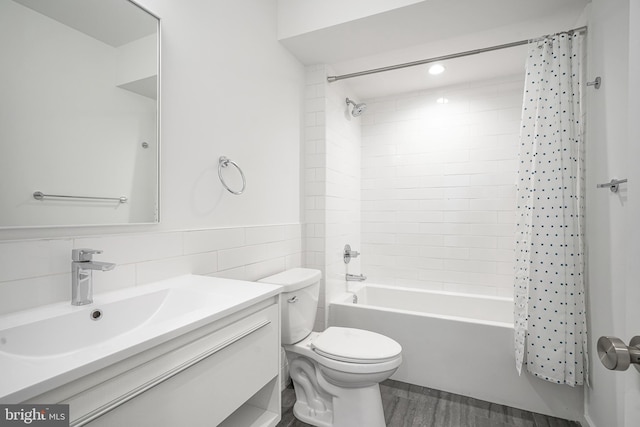 full bathroom with tile walls, vanity, wood-type flooring, shower / bath combination with curtain, and toilet