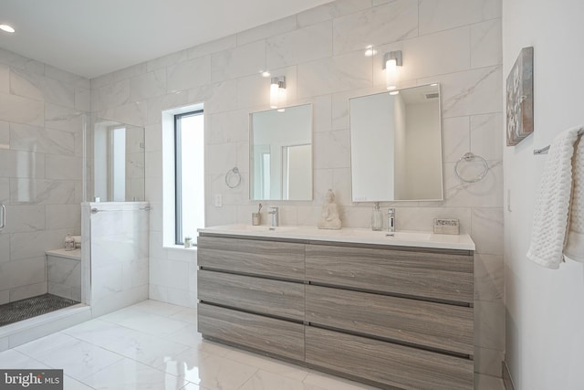 bathroom with a healthy amount of sunlight, vanity, an enclosed shower, and tile walls