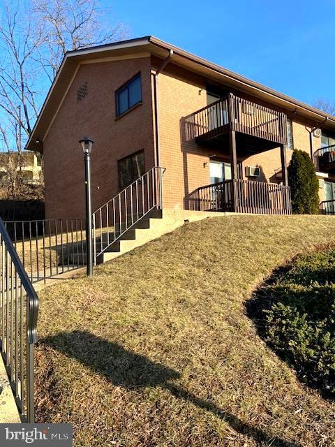 view of property exterior featuring a balcony and a yard